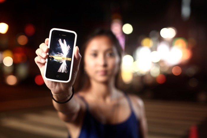 A girl holding a smartphone to the camera - travel photography equipment