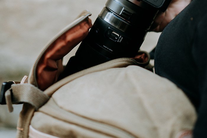 Closeup shot of a photographer pulling out a camera from the bag