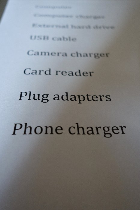 Close up of a travel photographers list of gear and best way to backup photos when travelling