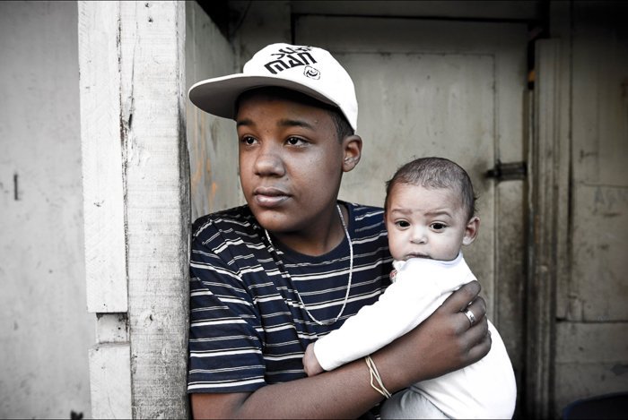 Portrait of a young man holding a small baby - local guide for better travel photography