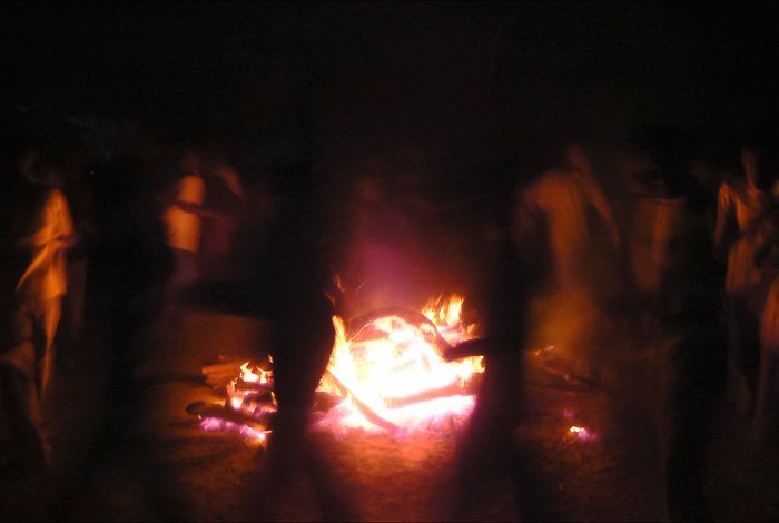 Atmospheric travel photography shot of people dancing around a fire